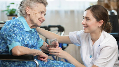 Eine Pflegerin betreut eine Seniorin in ihrer Wohnung.