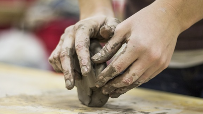 Bildhauerin bei der Arbeit. Die Hände sind besonders bei Arbeitsunfällen gefährdet.